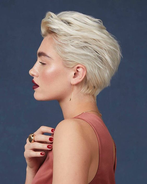 a blonde long pixie haircut with a lot of dimension and texture and a darker root is a cool and bold idea for a wedding