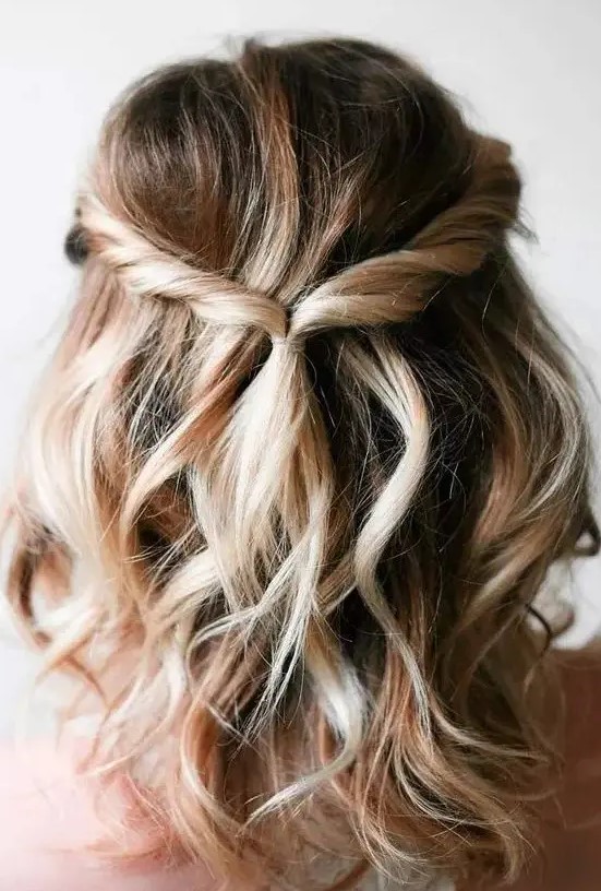 a boho half updo with twists, waves and some dimension and volume is perfect for a boho wedding