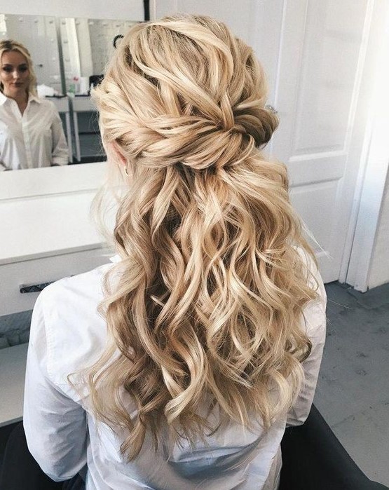 a chic wedding hairstyle with a twisted voluminous top, twisted braids and waves down is great for long hair