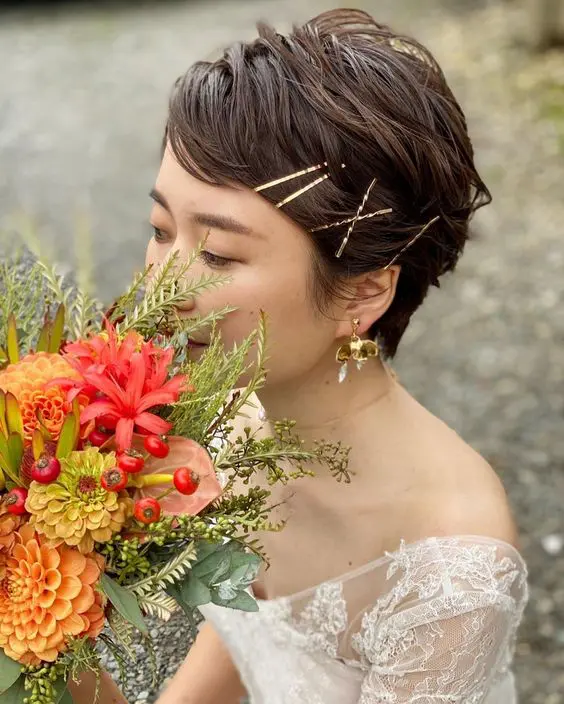 a dark brown wavy pixie haircut with gold hairpins is a beautiful and cool idea for a wedding