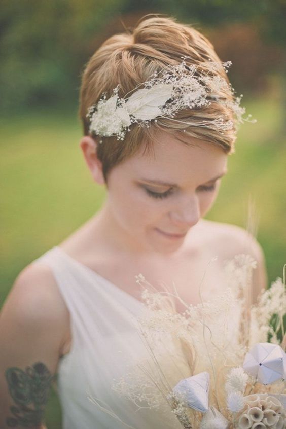 a ginger straight pixie haircut with a feather adn dried plant hair piece looks delicate and subtle and inspires