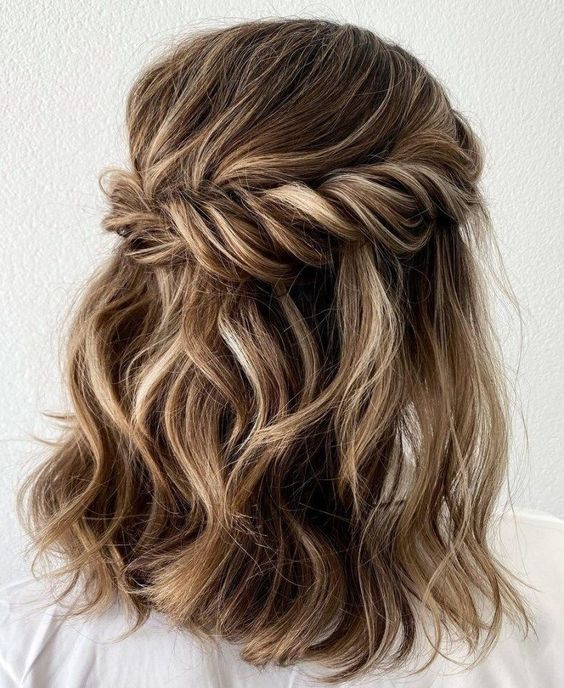 a lovely and pretty wavy half updo with a bump on top ,a  twisted looped halo and waves down is a cool idea for medium length hair