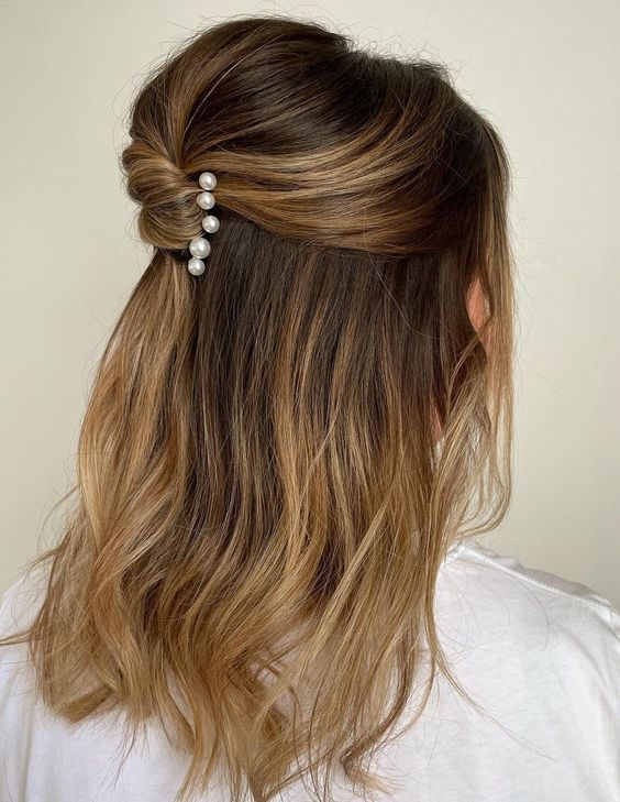 a lovely half updo with a bump on top and a twist accented with pearl hair pins is good for medium and long hair