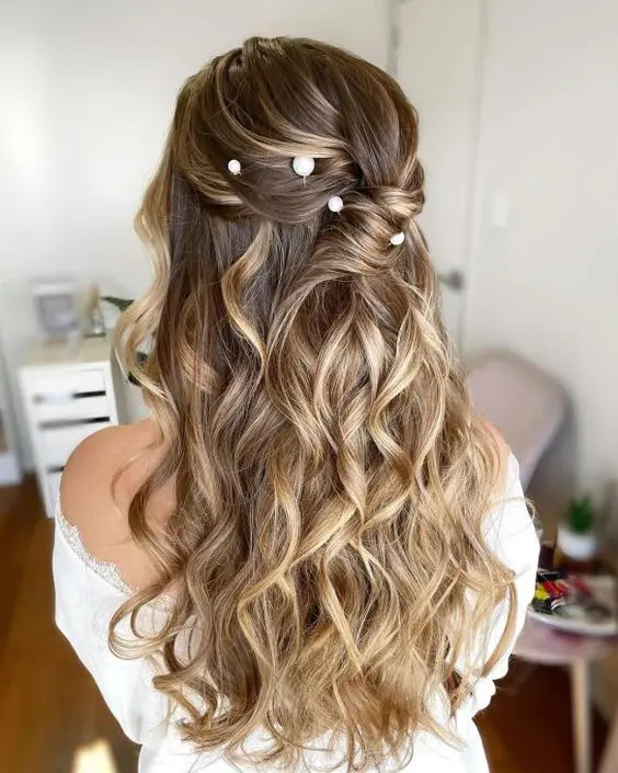 a romantic twisted half updo with lots of waves down and a bump on top, with pearl hair pins is a very chic solution for a wedding