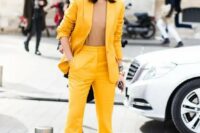 02 a bright yellow suit with flare pants, a camel top that matches the skin and a small clutch