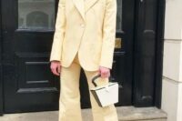 04 a light yellow pantsuit with flare pants and no top underneath, a two-tone bag, strappy shoes and a chunky chain necklace