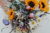 10 a beautiful and colorful wedding bouquet of pink and purple blooms,chamomiles, thistles, sunflowers and baby’s breath is amazing