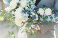 11 a beautiful wedding bouquet of white roses, blue blooms and thistles, greenery and long neutral ribbons is amazing