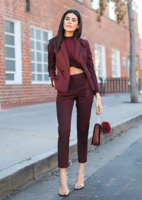 a total burgundy look with a twisted crop top, high waisted pants, a blazer, a bag, sheer shoes