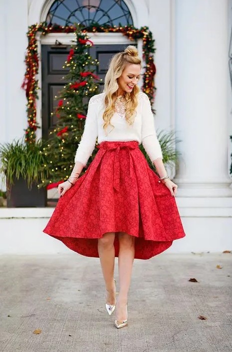 a red high low printed skirt with a bow, a white sweater and a statement necklace with silver shoes
