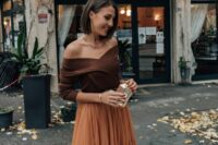14 an elegant fall wedding guest outfit with a brown off the shoulder top, a rust-colored tulle midi skirt and a small metallic clutch