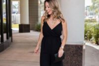 16 a black spaghetti strap jumpsuit with wideleg pants, a black clutch and a statement necklace