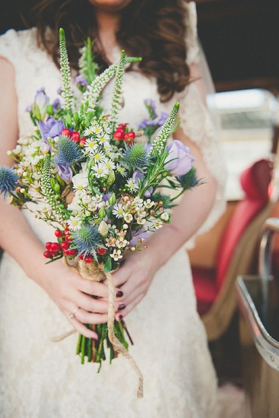 a bright and fun wedding bouquet with thistles, lilac and white blooms, berries and more details for an eye-catchy look