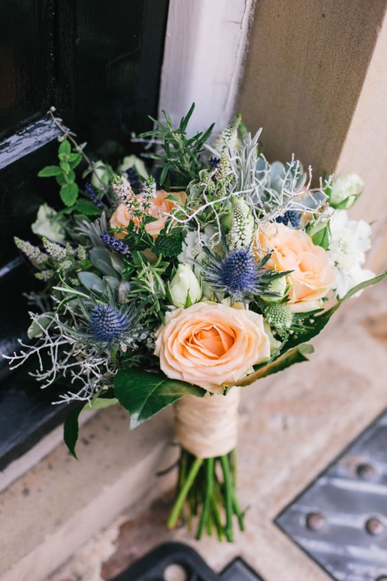 a catchy summer wedding bouquet of peachy roses, white blooms, greenery, astilbe and some foliage is a cool idea for summer