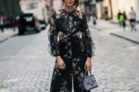 21 a gorgeous navy pantsuit with tan floral prints, with illusion sleeves, cropped pants, tan shoes and a light blue bag