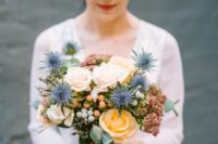 24 a delicate and catchy wedding bouquet of peachy and blush roses, thistles, berries and greenery is a stunning idea for summer
