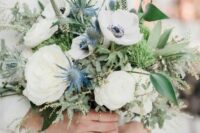26 a delicate wedding bouquet of white roses and anemones, blue thistles and various types of greenery for a spring or summer wedding