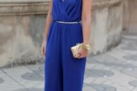 29 an electric blue jumpsuit with a V-neckline and palazzo pants, with a polished belt, a neckline and a mini clutch for a formal wedding guest look