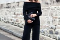 30 black culottes, a black strapless top with long sleeves, a black clutch and black mules
