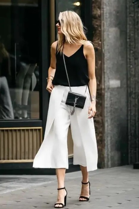 a black top, white wideleg pants, black heels and a mini bag for a chic monochromatic wedding guest look