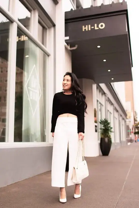 a bold and chic minimalist outfit with a black crop top, white wideleg pants, white shoes and a white bag