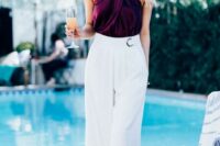 35 a bold summer wedding guest outfit with a deep purple criss cross top, white wideleg pants with pleating and statement earrings