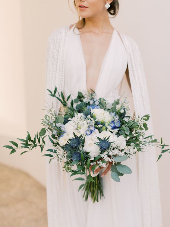 a gorgeous textural wedding bouquet of white roses, greenery, thistles is a super lush and adorable wedding arrangement