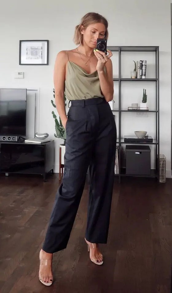 a bold wedding guest look with an olive green spaghetti strap top, black leather pants, clear heeled mules and layered necklaces