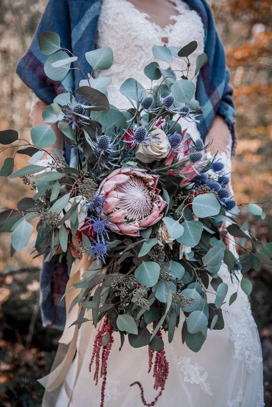 a jaw-dropping wedding bouquet with king proteas, thistles, amaranthus and lots of eucalyptus will make a statement