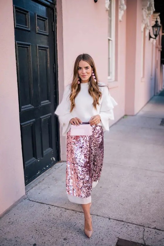 a pink sequin midi skirt with a white edge, a white angora sweater with ruffled sleeves, pink earrings and nude heels