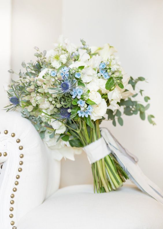 a lovely wedding bouquet of white blooms, blue flowers and thistles and some greenery is a stylish and catchy idea