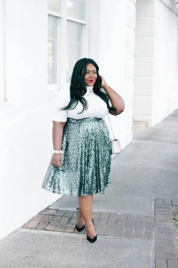 A white turleneck with short sleeves, a green high waist sequin midi, black shoes and an off white bag