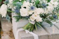 46 a luxurious wedding bouquet of white roses, thistles, greenery is a super textural and lush arrangement with ribbons