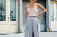 47 a summer wedding outfit with lavender-colored wideleg pants, a blush spaghetti strap top, white shoes and statement earrings