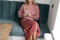51 a cozy wedding guest outfit with a pink chunky knit sweater, a red printed sequin skirt, black shoes and pearl earrings