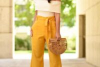 51 high waisted yellow pants, a creamy off the shoulder top, a straw bag and statement earrings