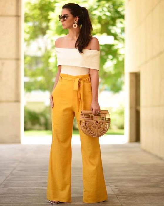 high waisted yellow pants, a creamy off the shoulder top, a straw bag and statement earrings