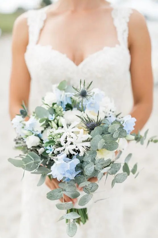 a subtle wedding bouquet of white and serenity blue flowers, thistles, greenery is a chic and delicate idea for a spring wedding