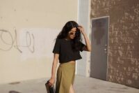 54 a modern and casual wedding guest look with a black crop top, a mustard-colored maxi skirt with a thigh high slit, black shoes and a clutch