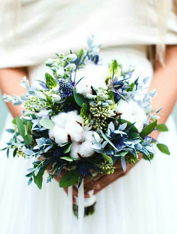 a winter wedding bouquet of cotton, greenery and blue thistles is a cool and cozy idea for a cold weather wedding