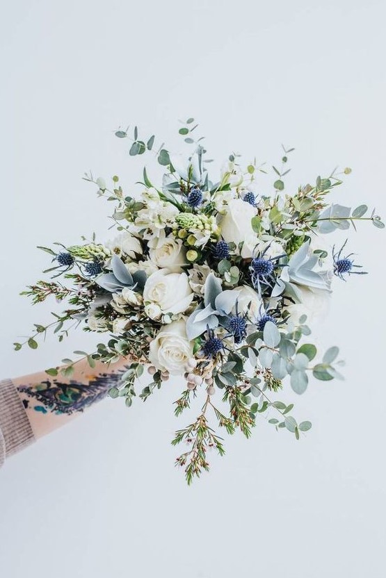 an ethereal wedding bouquet with white roses, thistles, berries and pale greenery is a fantastic idea for a spring or summer bride