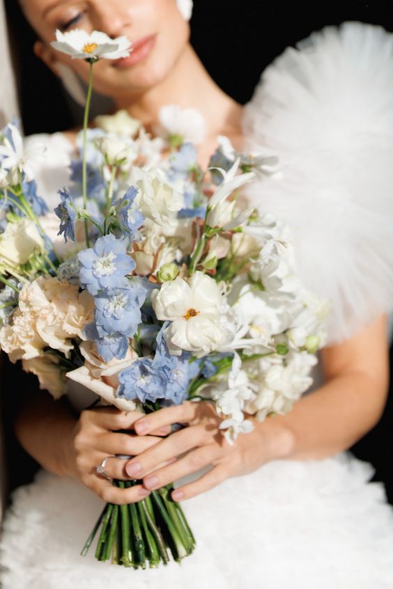 a beautiful and delicate wedding bouquet of white and blue flowers is a fresh and cool idea for a non-formal wedding