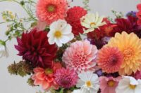 a beautiful dahlia wedding bouquet of pink, rust, burgundy, yellow and white blooms and some chamomiles for a fall wedding
