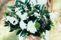 a beautiful modern wedding bouquet of white dahlias, berries, astilbe, black and green foliage is amazing