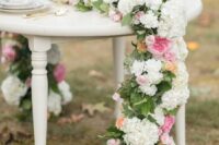 a beautiful wedding table runner with white hydrangeas, peachy and pink peony roses and greenery is a lovely solution