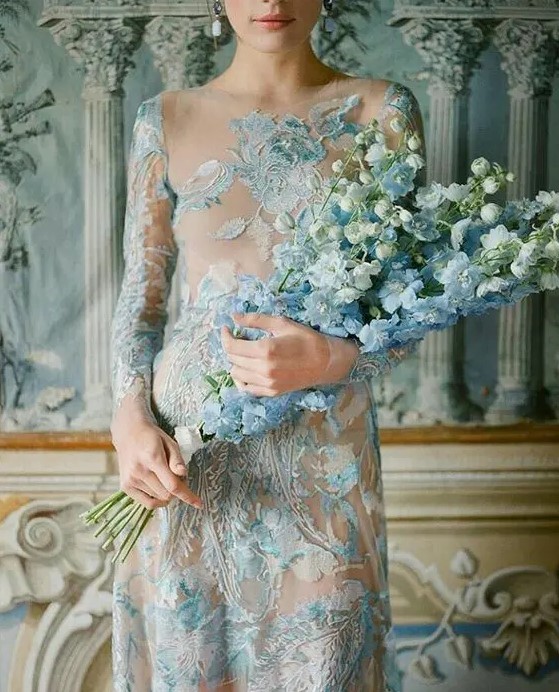 a blue lace applique and embroidery wedding dress paired up with a blue and white delphinium wedding bouquet