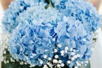 a blue wedding bouquet of hydrangeas, baby’s breath and leaves is a cool way to make a statement with color