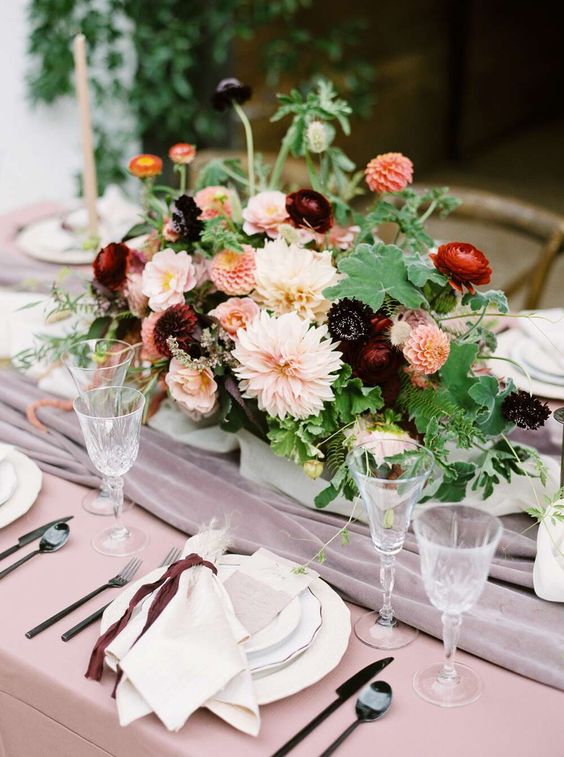 a bold and contrasting summer wedding centerpiece of pink, blush and deep burgundy dahlias and greenery is very refined
