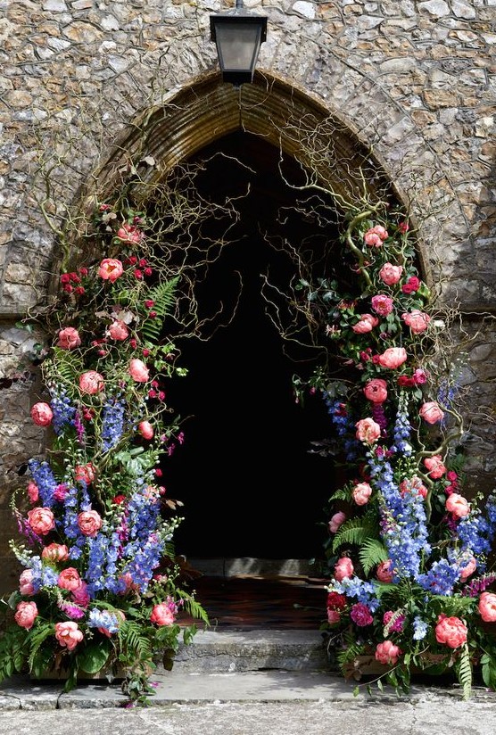 a bold floral wedding arch decorated with twigs, fern, delphinium and pink peonies look spectacular