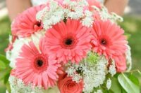 a bold wedding bouquet of coral gerberas and roses, some fillers and leaves is a catchy solution that makes a statement with color